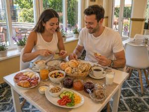 a man and woman sitting at a table eating food at Doris Hotel in Siófok