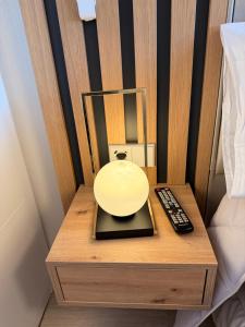 a nightstand with a remote control next to a bed at Apartamento Blois Deluxe in Rivas-Vaciamadrid