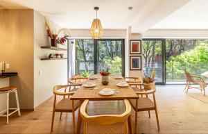 a dining room with a wooden table and chairs at Casa Taman by Kukun in Mexico City +10 photos