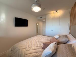 a bedroom with a bed and a flat screen tv at Apartamento Blois Deluxe in Rivas-Vaciamadrid