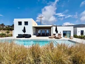 a house with a swimming pool in front of a house at Faragas Hill Oasis Villa in Angairiá