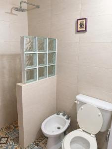 a bathroom with a toilet and a window at Duplex Mi Lar in Termas de Río Hondo