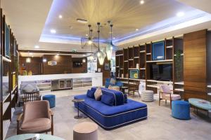 a living room with a blue couch and chairs at Hampton by Hilton Istanbul Kayasehir in Istanbul