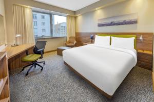 a hotel room with a large bed and a desk at Hampton by Hilton Istanbul Kayasehir in Istanbul +27 photos