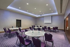 a conference room with tables and purple chairs at Hampton by Hilton Istanbul Kayasehir in Istanbul
