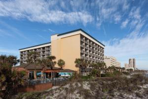 a hotel on the beach with palm trees at Hampton Inn Oceanfront Jacksonville Beach in Jacksonville Beach