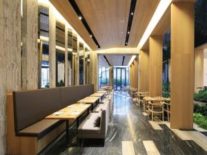 South Urban Hotel في مدينة تشيايي: غرفة طعام مع طاولات وكراسي ونوافذ