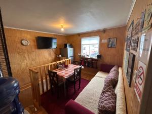 a small dining room with a table and a kitchen at Ruta Pata Austral in Puerto Varas