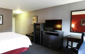 a hotel room with a bed and a flat screen tv at Hampton Inn & Suites Temecula in Temecula