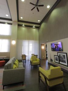 a waiting room with couches and chairs and a flat screen tv at Hampton Inn & Suites Seal Beach in Seal Beach