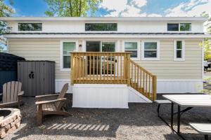 a tiny house with a deck and a patio at Pool • Fire Pit • Amenities • Sleeps 8 in Swain