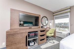 a bedroom with a tv and a desk with a chair at Hampton Inn Morgantown in Morgantown +12 photos