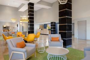 a lobby with chairs and tables and a waiting area at Spark by Hilton Tucson Reid Park in Tucson