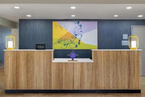 a lobby with a reception desk with a painting on the wall at Spark by Hilton Tucson Reid Park in Tucson