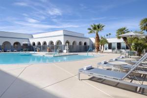 a swimming pool with lounge chairs and a resort at Spark by Hilton Tucson Reid Park in Tucson