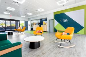 a waiting area with chairs and tables in a office at Spark by Hilton Ponce in Ponce