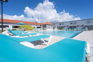 a swimming pool with lounge chairs and a hotel at Spark by Hilton Ponce in Ponce +38 photos