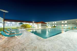 a swimming pool with lounge chairs in front of a building at Spark by Hilton Ponce in Ponce