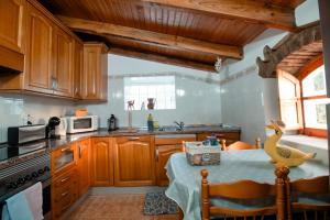 a kitchen with wooden cabinets and a table with a duck on it at Casa Da Maria - Villa with Private Pool and Barbecue in Fonte do Bispo