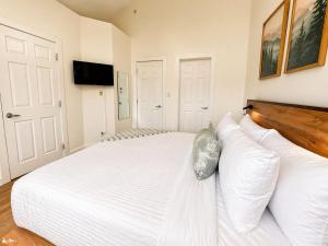 a bedroom with a large white bed with white pillows at Alpine Hideaway at Alpine Village in Canmore +38 photos