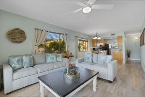 a living room with a couch and a table at Oceanview - Steps to Beach - King Suite - Pool - Arcade in Clearwater Beach