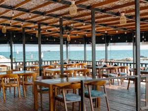 a restaurant on the beach with tables and chairs at At Kelly's Ambalangoda in Ambalangoda