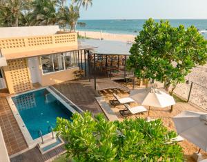 an aerial view of a resort with a swimming pool and the beach at At Kelly's Ambalangoda in Ambalangoda