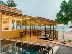 a restaurant on the beach with a swimming pool at At Kelly's Ambalangoda in Ambalangoda