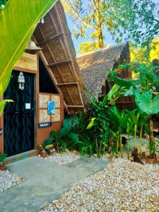 a house with a thatched roof and a door at MyLove Siargao Village in General Luna