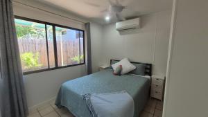 a small bedroom with a bed and a window at Stay on Sooning in Nelly Bay +9 photos