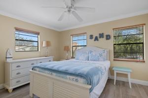 a bedroom with a bed and a ceiling fan at Oceanview - Steps to Beach - King Suite - Pool - Arcade in Clearwater Beach