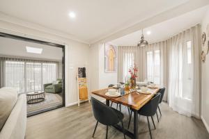 a dining room and living room with a table and chairs at Pacific Palms Retreat - Entire Home in Plumpton Sleeps 9 - 8-Car Parking Near Eastern Creek in Rooty Hill
