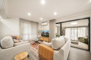 a living room with two couches and a table at Pacific Palms Retreat - Entire Home in Plumpton Sleeps 9 - 8-Car Parking Near Eastern Creek in Rooty Hill