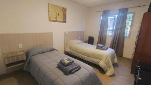 a hotel room with two beds and a ottoman at Depto B in Rincon de los Sauces
