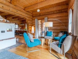 a living room with wooden ceilings and blue chairs at Janna in Mauterndorf