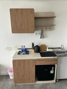 a kitchen with wooden cabinets and a counter top at Kawoeng skyhouse BSD in Cilenggang