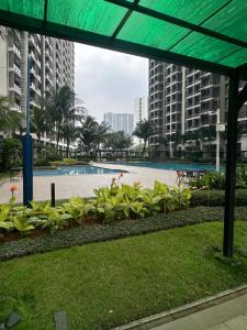 a park with a pool and some plants and buildings at Kawoeng skyhouse BSD in Cilenggang