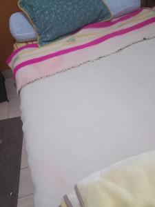a white bed with pillows on top of it at Hôtel des cedresazrou in Azrou +1 photo