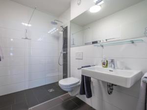 a white bathroom with a toilet and a sink at Emma Top 1 in Dienten am Hochkönig +36 photos