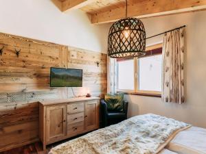a bedroom with a bed and a tv on a wall at Bernkogel Penthouse in Rauris