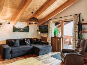 a living room with a couch and a tv at Bernkogel Penthouse in Rauris