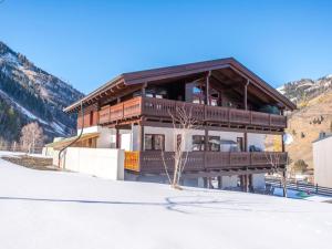 a house in the snow in front of a mountain at Bernkogel Penthouse in Rauris