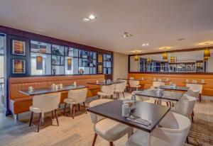 a restaurant with tables and chairs and a bar at DoubleTree by Hilton London Ealing in London