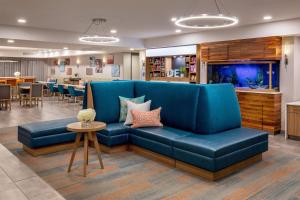 a living room with a blue couch and a fish tank at Hampton Inn Rehoboth Beach in Rehoboth Beach