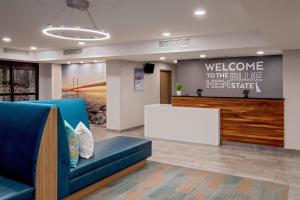a waiting room with a blue couch and a welcome to the blue them share sign at Hampton Inn Rehoboth Beach in Rehoboth Beach +57 photos