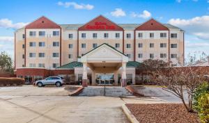 a large building with a car parked in front of it at Hilton Garden Inn Starkville in Starkville