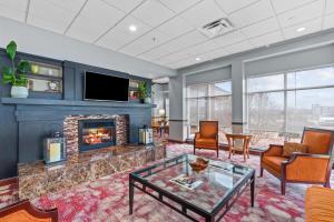 a living room with a fireplace and a tv at Hilton Garden Inn Starkville in Starkville