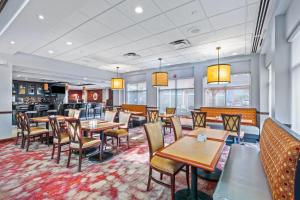 a restaurant with tables and chairs and a bar at Hilton Garden Inn Starkville in Starkville