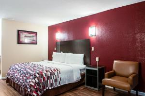 a hotel room with a bed and a chair at Red Roof Inn Slidell in Slidell +28 photos