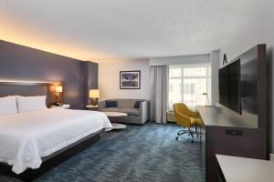 a hotel room with a bed and a couch and a television at Hampton Inn Washington DC - Convention Center in Washington, D.C. +64 photos